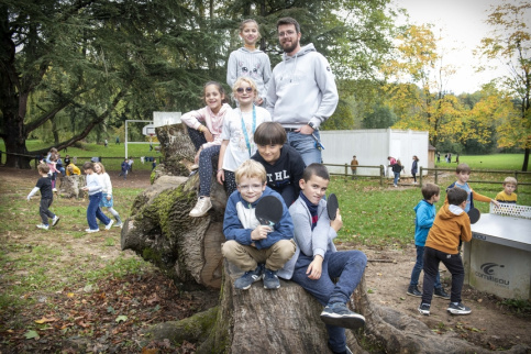 Groupe d'enfant avec un éducateur pendant la récréation dans le parc de l'école