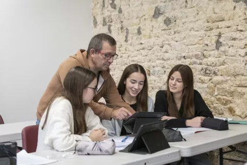 3 jeunes filles avec un éducateur qui les accompagne en classe